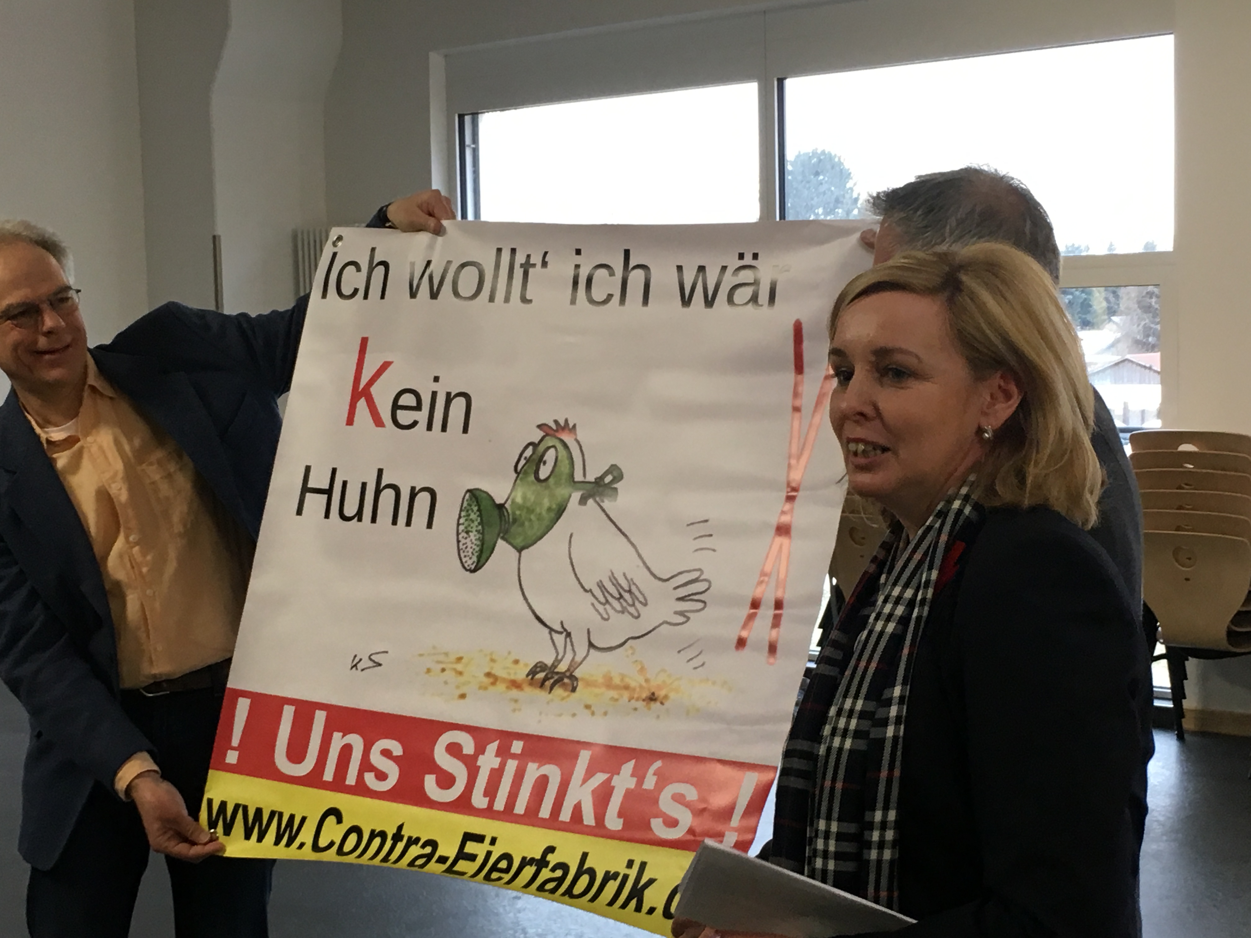 Heiner Klemp (links) nimmt von Heike Bartel und Horst Jäkel (verdeckt) ein Plakat der Bürgerinitiative entgegen.